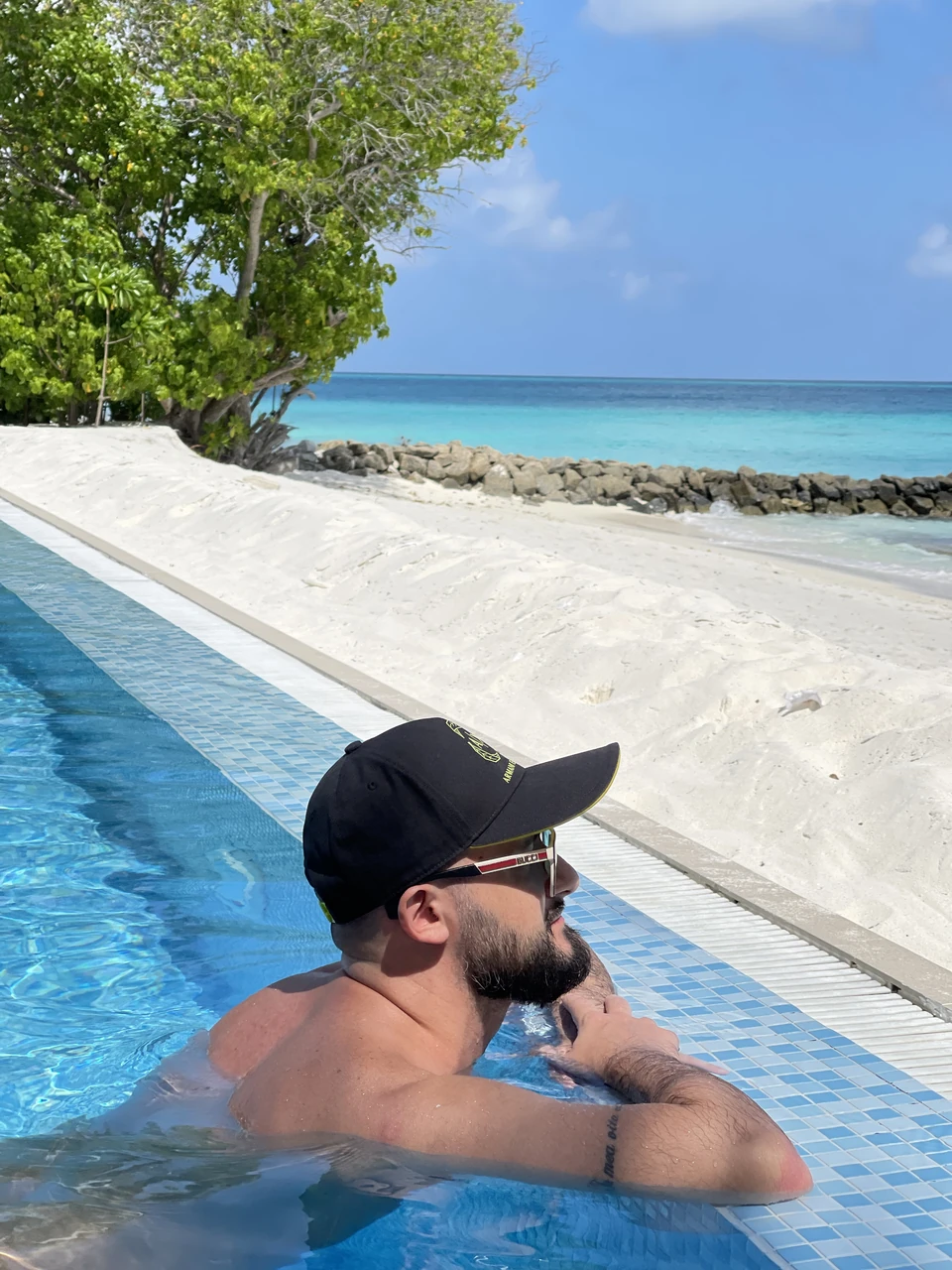 Артём Gameleon в жёлтой куртке стоит на краю скалы Тролльтунга над глубоким норвежским фьордом